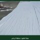 طبقة عزل بيضاء مطبقة بالرولة على سطح مع شعار همة الخليج